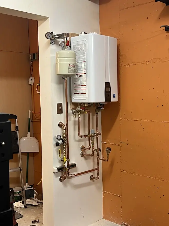 Plumbing technician inspecting water heater connections in Vancouver